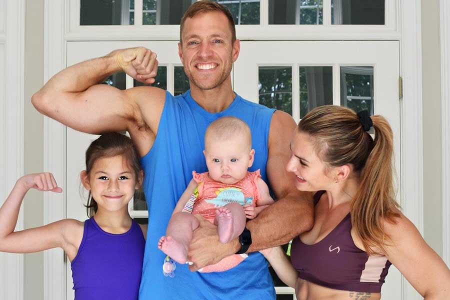 Dr. Robert Gildner wearing a blue athletic tank next to his wife and two daughters