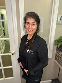 Lindy Garrick, office manager, wearing a black smock in the doorway at Gildner Family Dentistry in Lexington, SC
