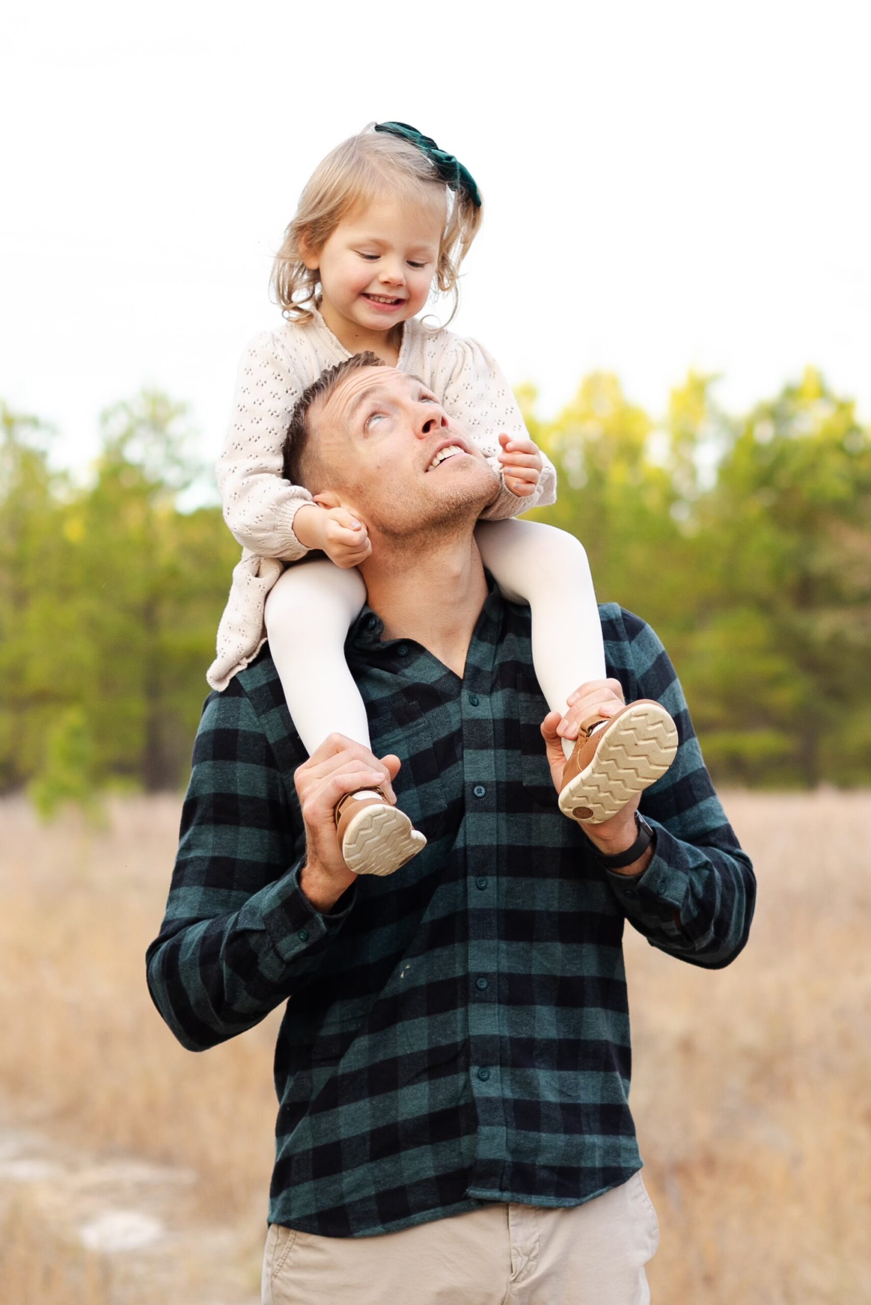 Dr. Robert Gildner,holds his daughter on his shoulders in a field in Lexington, SC