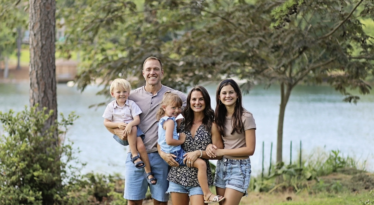 Dr. Robert Gildner,holds his daughter on his shoulders in a field in Lexington, SC
